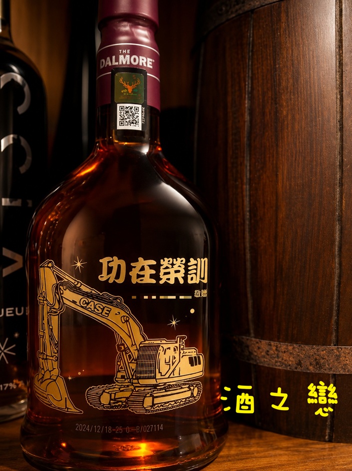 工程機具酒瓶雕刻作品,以工作機具圖案搭配姓名與職涯紀念文字設計